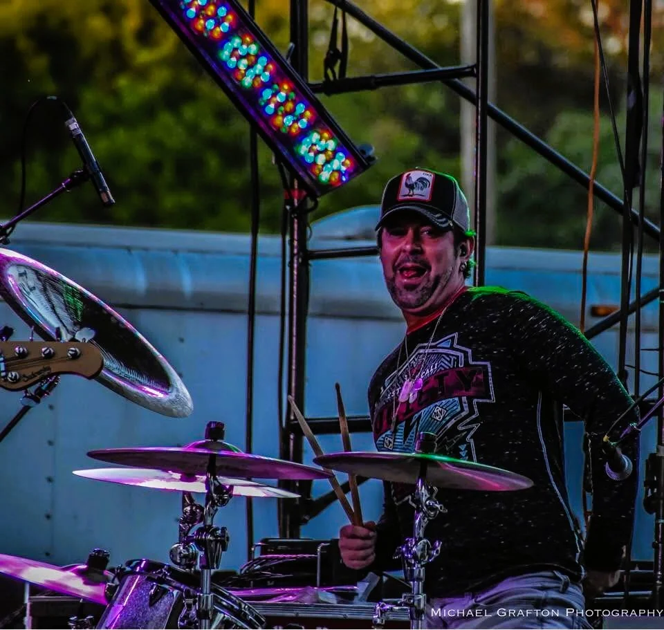 CA Anderson playing drums live on stage.